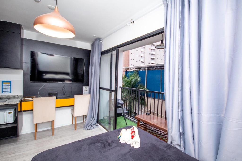 a room with a bed and a kitchen with a large window at Maison Perdizes - Allianz Parque Supreme in Sao Paulo