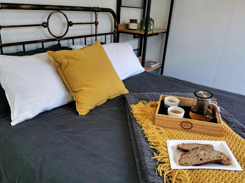 a tray of bread and eggs on a bed at Tuia Retreat in Whangaparaoa