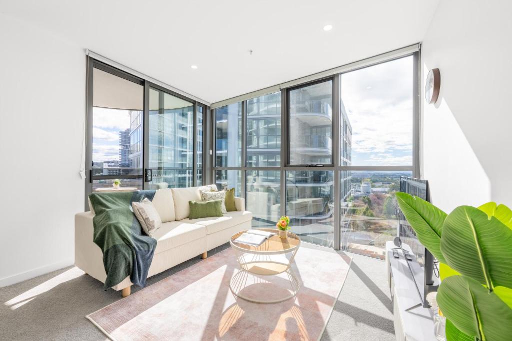 a living room with a white couch and large windows at Mountain View Woden Apt, Hospital, Westfield in Phillip