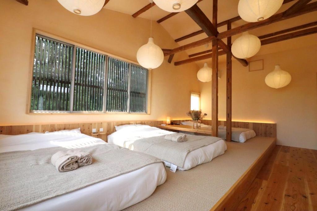 two beds in a room with two windows at 水縹日光 in Nikko
