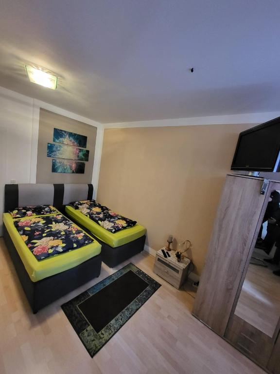 a room with two beds and a flat screen tv at Unterkunftsresidenz in Erfurt