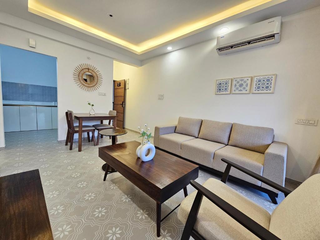 a living room with a couch and a table at Rustic 1BHK Apartment, Gym, Pool, Amenities - Near Candolim Beach in Candolim