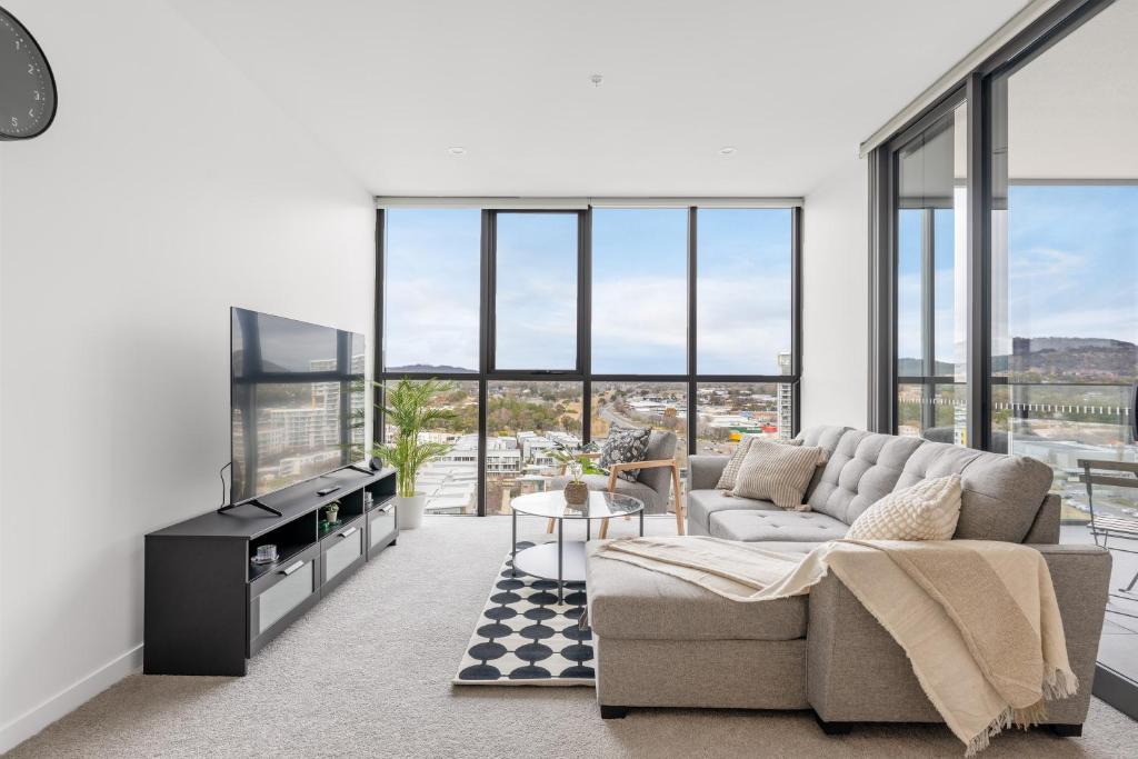 a living room with a couch and a table at Cosy Woden Apt Near Canberra Hospital,Transport in Phillip