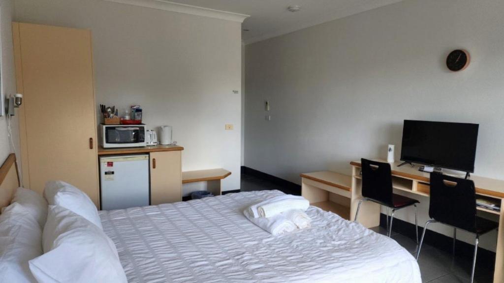 サセックス・インレットにあるJopen Motel Unit 4のベッドとパソコン付きの机がある寝室