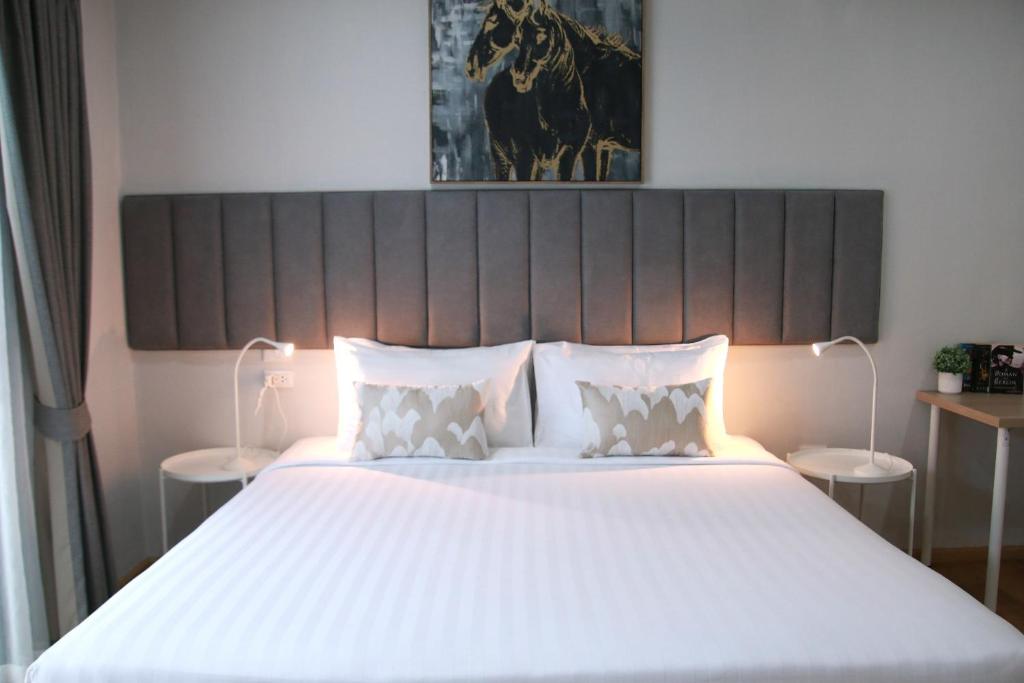 a bedroom with a large bed with white sheets and pillows at Xen Pool Access in Chalong 