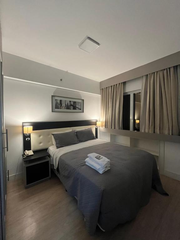 a bedroom with a large bed with two towels on it at Hotel Mercu Beneficência Portuguesa Com Garagem 208 in Sao Paulo