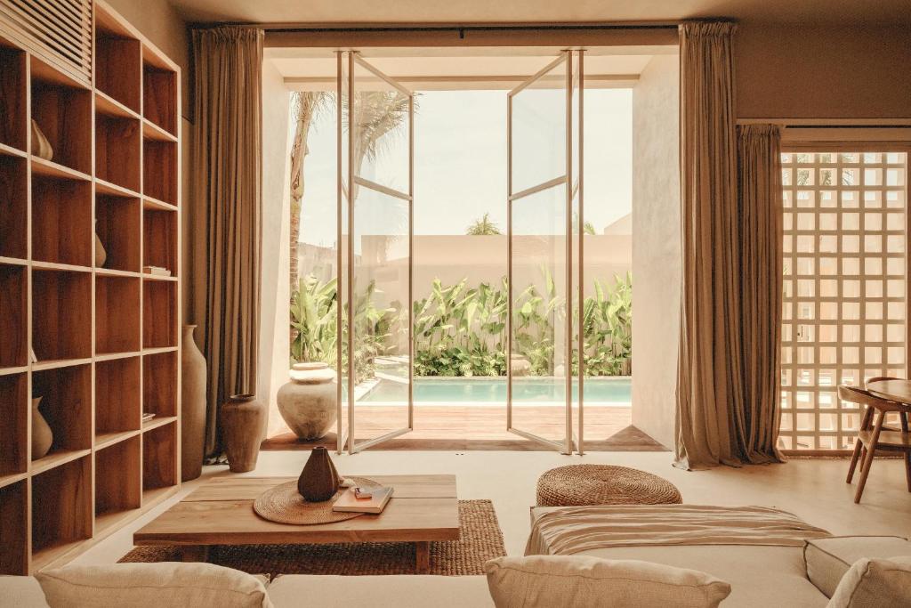 un salon avec un canapé et une grande fenêtre dans l'établissement NORI Boutique Villas, Near Nyang Nyang Beach, Uluwatu, à Uluwatu