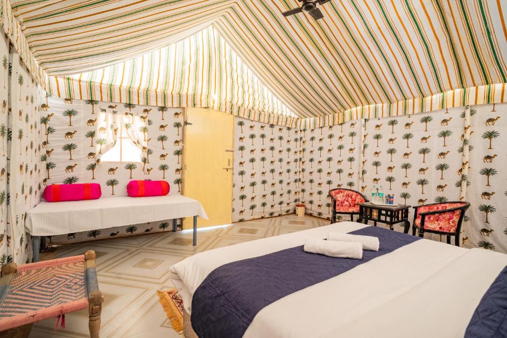 Un dormitorio con una cama y una mesa y sillas. en Sand Routes Resort & Desert Camp, en Sām