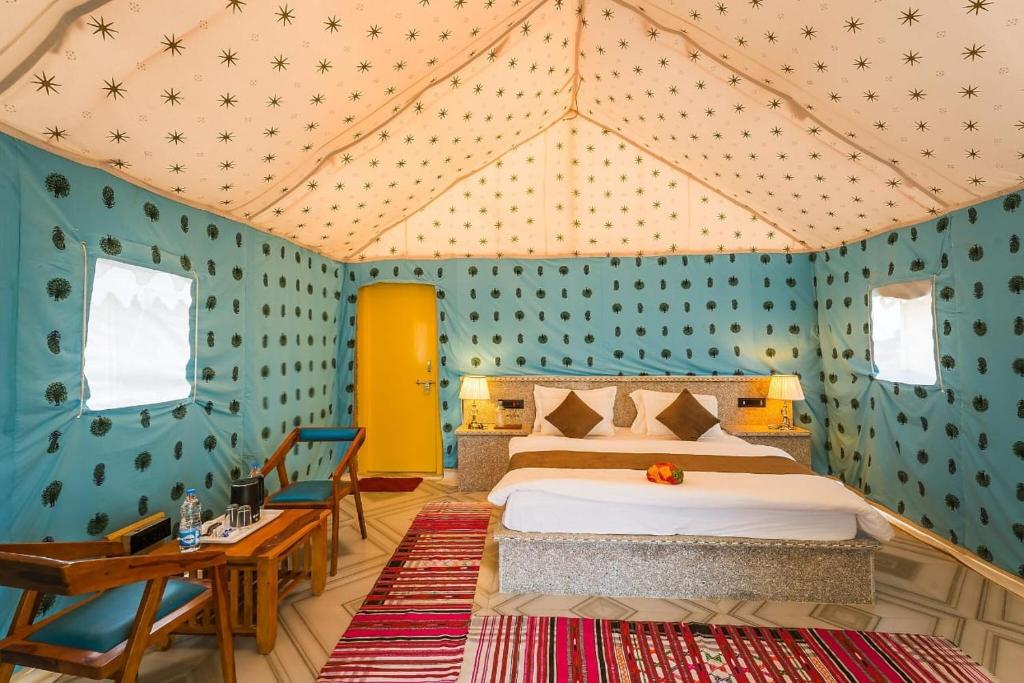a bedroom with a bed in a tent at Sand Routes Resort & Desert Camp in Sām