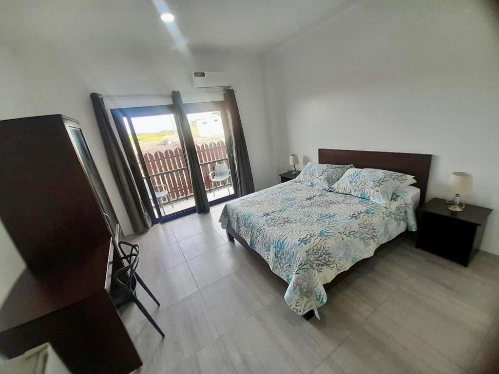 a bedroom with a bed and a large window at Chez Nemo in Puerto Villamil