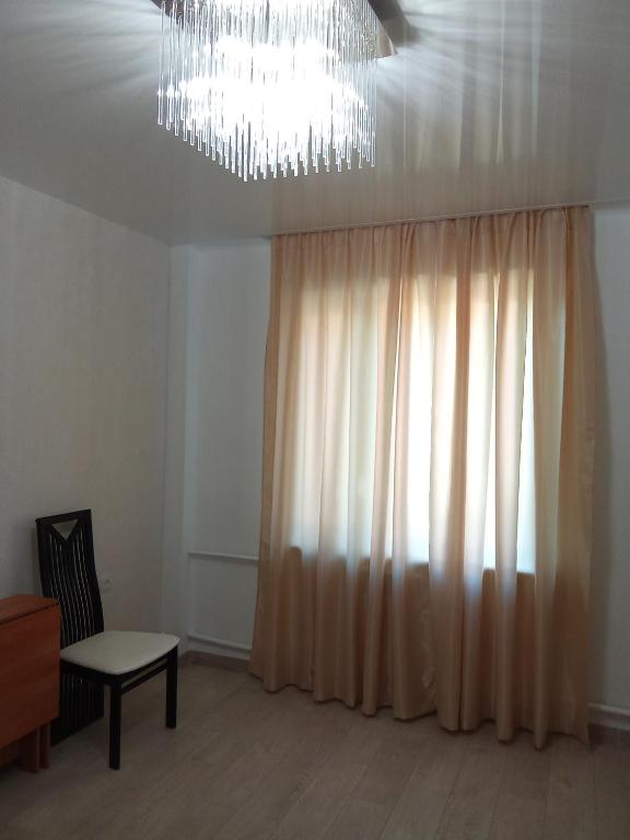 a living room with a chandelier and a window at Ботанічний Сад in Kharkiv
