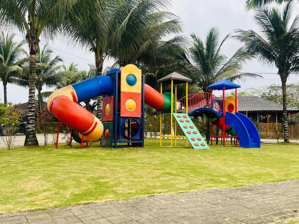 a park with a playground with a slide and a slideintend at Casa Vacacional Valles de Olon in Santa Elena