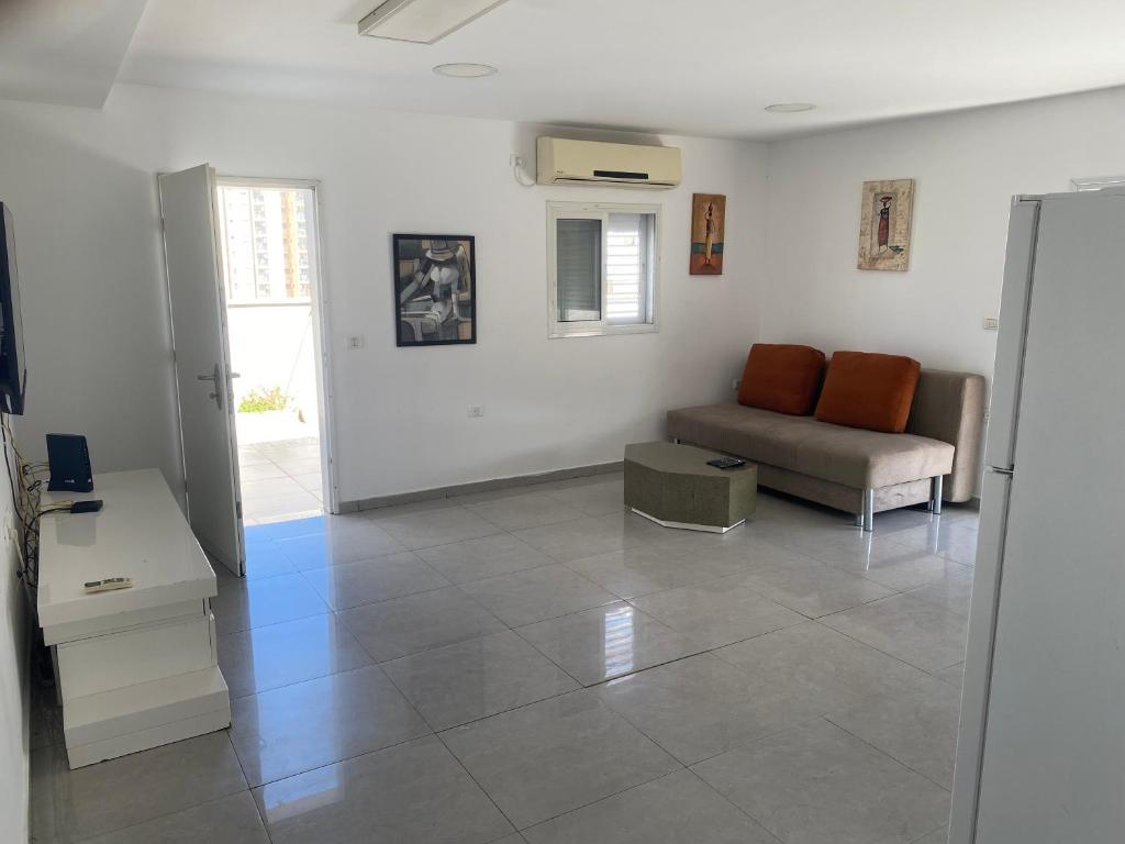 a living room with a couch and a table at פנטהאוז in Petaẖ Tiqwa