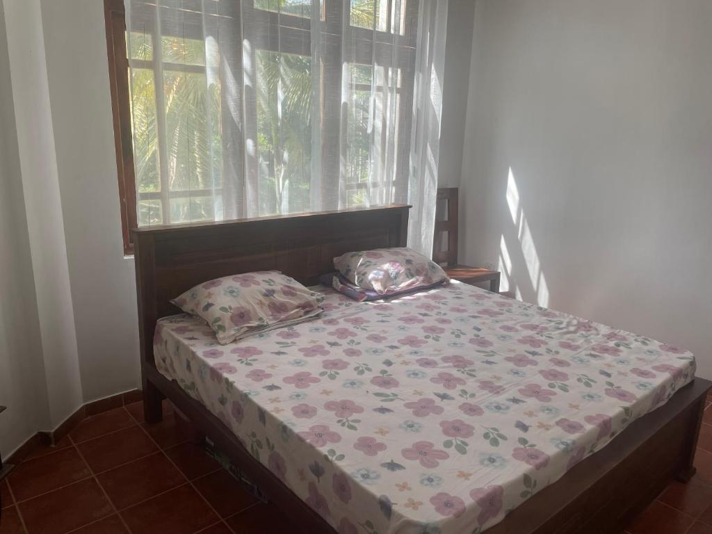 a bed with two pillows in a room with a window at Wickfield Kandy in Kandy