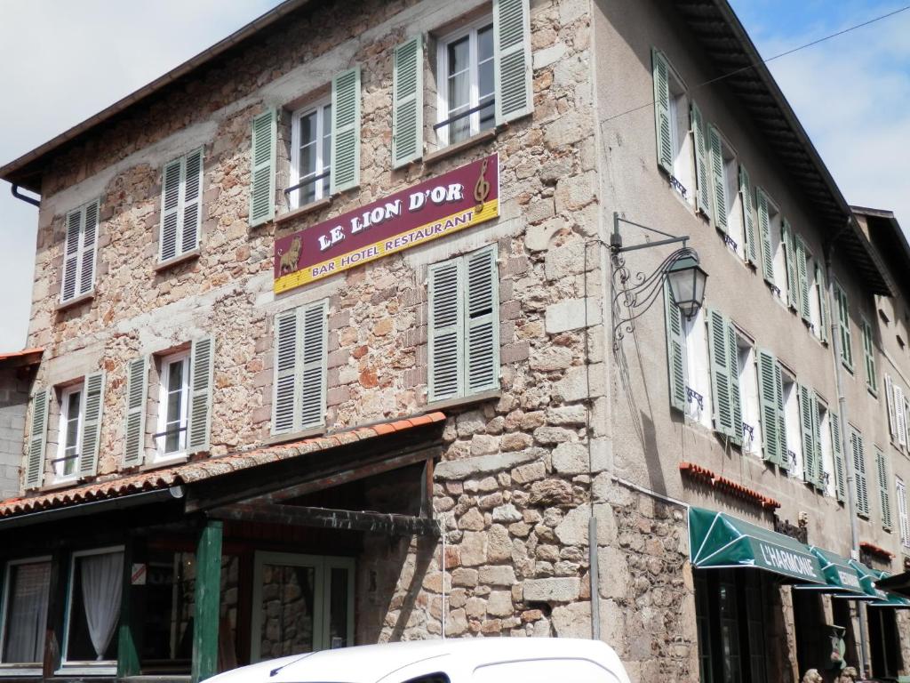 ein Gebäude mit einem Schild an der Seite in der Unterkunft Le Lion d'Or in La Chaise-Dieu