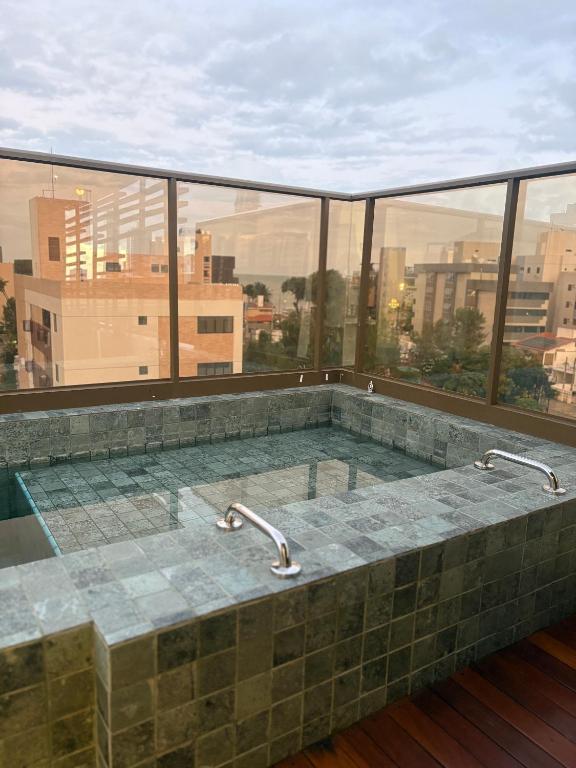 a jacuzzi tub with a view of a city at Flat Moderno a 100m da Praia do Bessa in João Pessoa