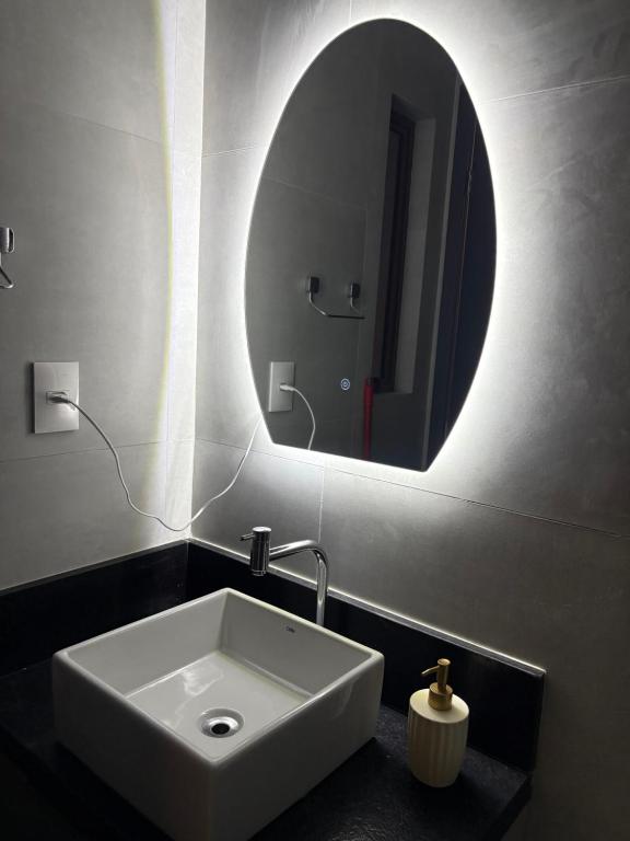 un bagno con un lavandino e un grande specchio di Flat Moderno a 100m da Praia do Bessa a João Pessoa