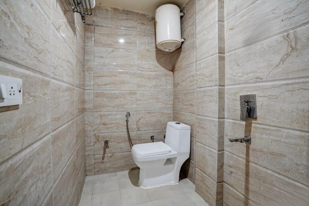 a bathroom with a white toilet in a room at Hotel Grand Lowsan Airport in New Delhi