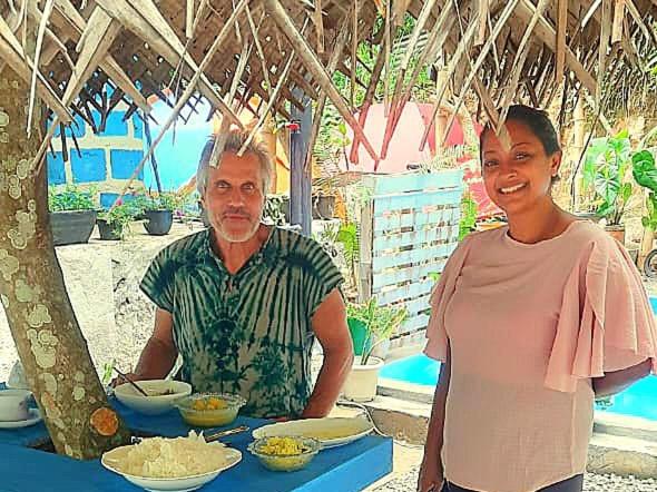 a man and a woman standing in front of a table with food at Sky Blue Cabin in Kandy
