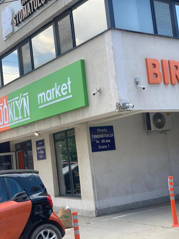 a store with a car parked in front of it at apartament 1 camera in Roşu