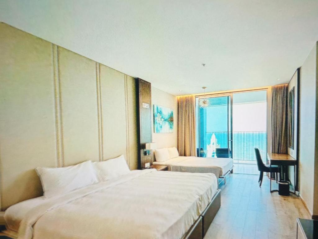 a hotel room with two beds and a desk at MELLIA OCEANUS NHA TRANG BAY Five-Star Suites in Nha Trang