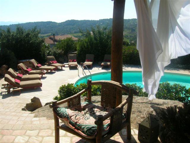 a group of chairs sitting next to a swimming pool at Villa Dolce Vita in Cannigione