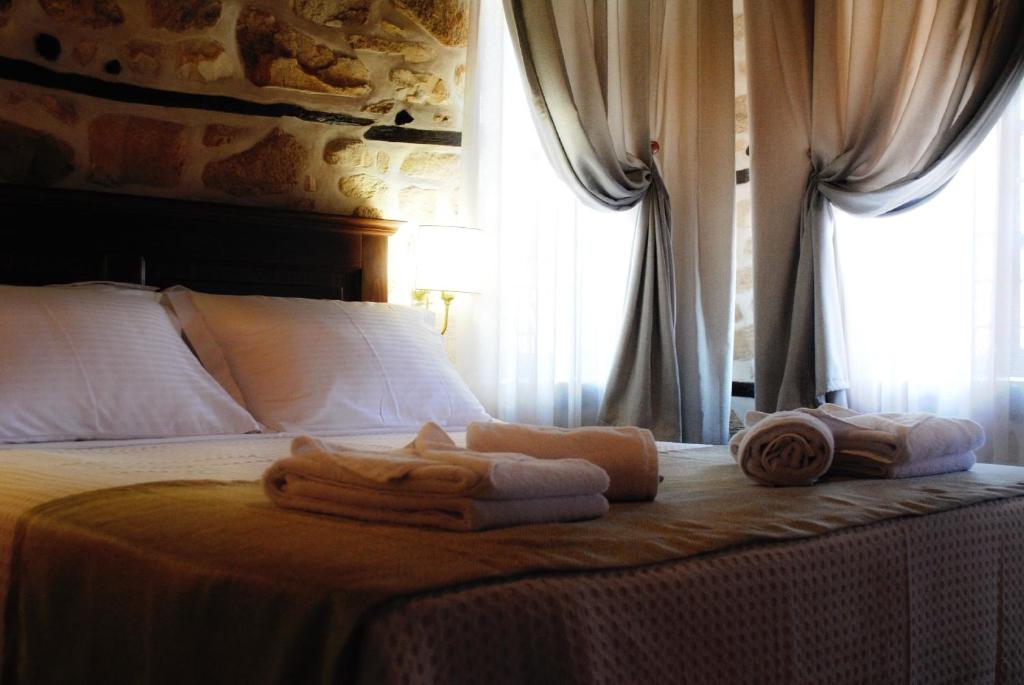 a bedroom with a bed with towels on it at Chorostasi Mansion in Arnaia