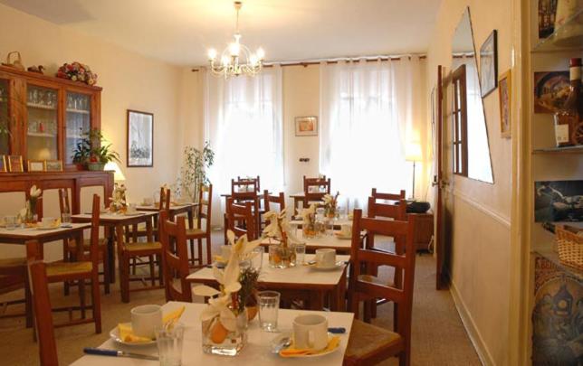 un comedor con mesas y sillas en un restaurante en Hotel Henri IV, en Saint-Valéry-en-Caux