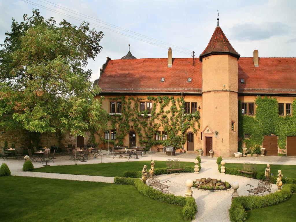 ein großes Gebäude mit einem Garten davor in der Unterkunft Wörners Schloss Weingut & Wellness-Hotel in Prichsenstadt