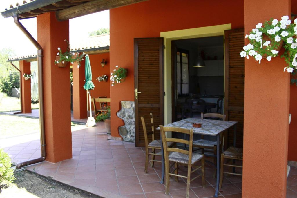 une salle à manger avec une table et des chaises sur une terrasse dans l'établissement Agriturismo Debbione Marconi, à Suvereto