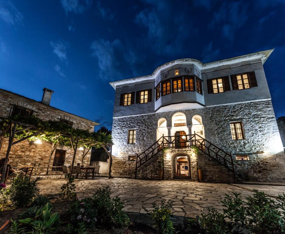 a large stone building at night with lights at Archontiko Filippidi in Mileai