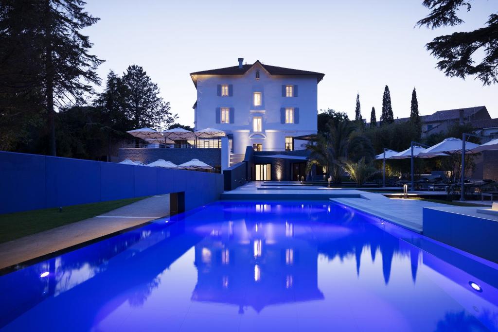 a villa with a swimming pool in front of a house at Château Autignac in Autignac