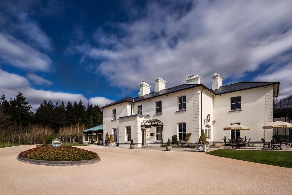 a large white house with a circular driveway at The Lodge at Ashford Castle in Cong