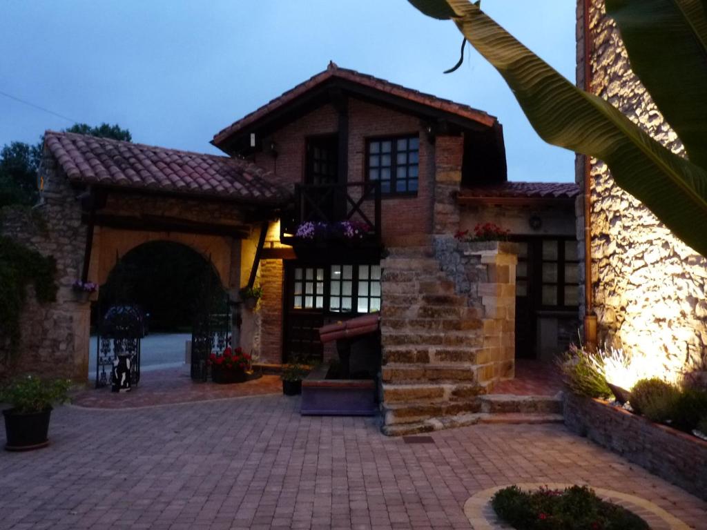 uma casa de tijolos com um arco e uma entrada de tijolos em Posada El Pozo em Castanedo