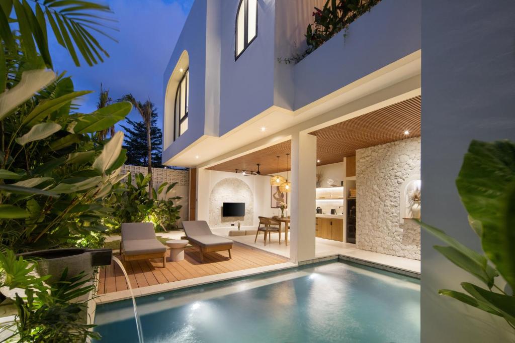 an indoor swimming pool in a house with a patio at Solaya Villas Canggu in Canggu