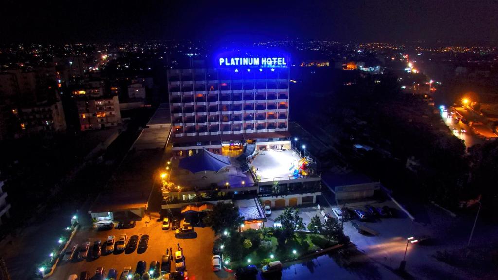 ein Gebäude mit einem Schild auf dem Dach bei Nacht in der Unterkunft Platinum Hotel in Tyros