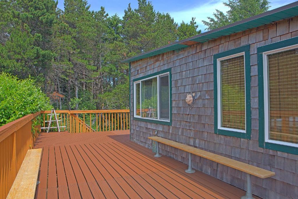 a wooden deck with a bench and a window at The Dragonfly Cabin in Grayland