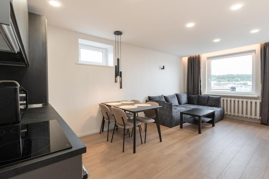 a living room with a couch and a table and chairs at Panorama City View Apartment in Vilnius