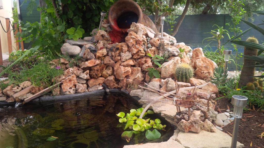 um jardim com uma pilha de pedras e um lago em Follow Me B&B em San Salvo