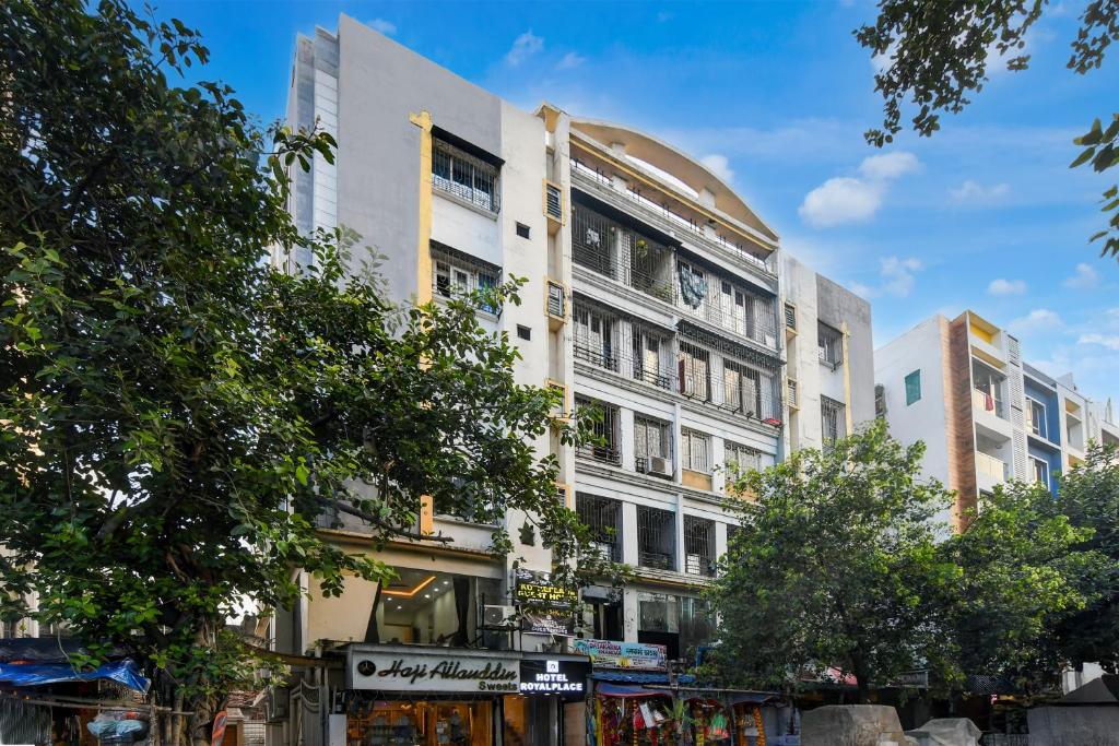 a tall white building on a city street at Hotel Royal Place in Kolkata