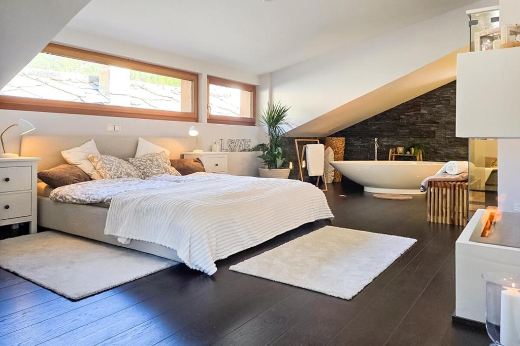 a bedroom with a large bed and a bath tub at Traumhafte Ferienwohnung in den Schweizer Alpen in Saas-Grund