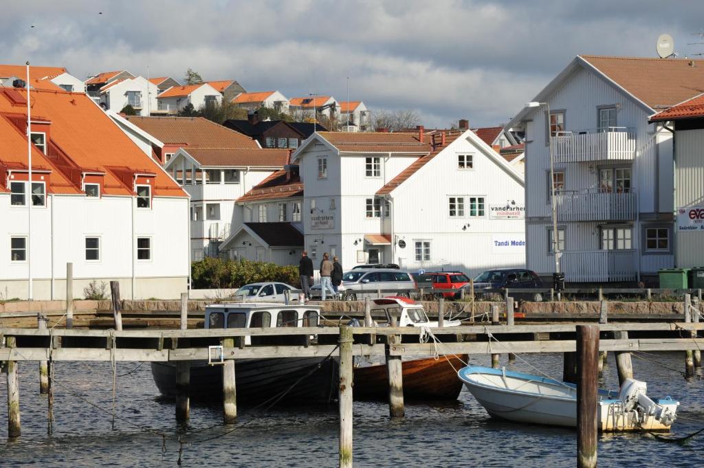 un bateau est amarré à côté d'un quai avec des maisons dans l'établissement Grebbestads Vandrarhem, à Grebbestad