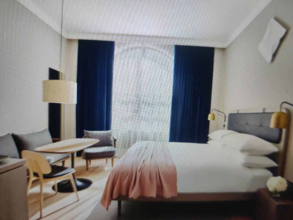 Un dormitorio con una cama y una mesa y una ventana. en Hotel Abhinandan, en Manali