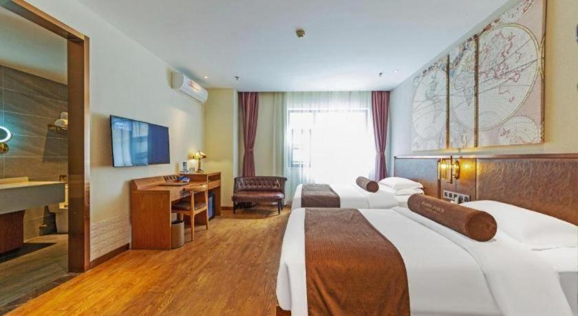 a hotel room with two beds and a desk at James Joyce Coffetel Xi'an Lingtong The Terracotta Army Huaqingchi University Town Metro Station in Xi'an