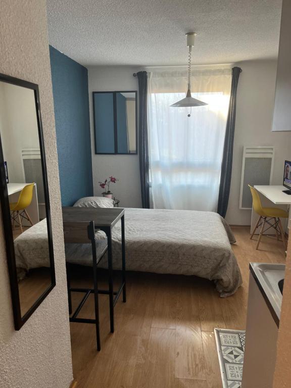 a bedroom with a bed and a table and a mirror at Studio Sacré Cœur Proche Basilique - N 319 in Paray-le-Monial