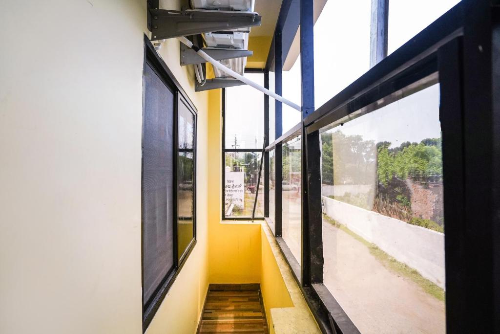 Un pasillo de un edificio escolar con ventanas. en Hotel O Sai Saugat, en Bilāspur