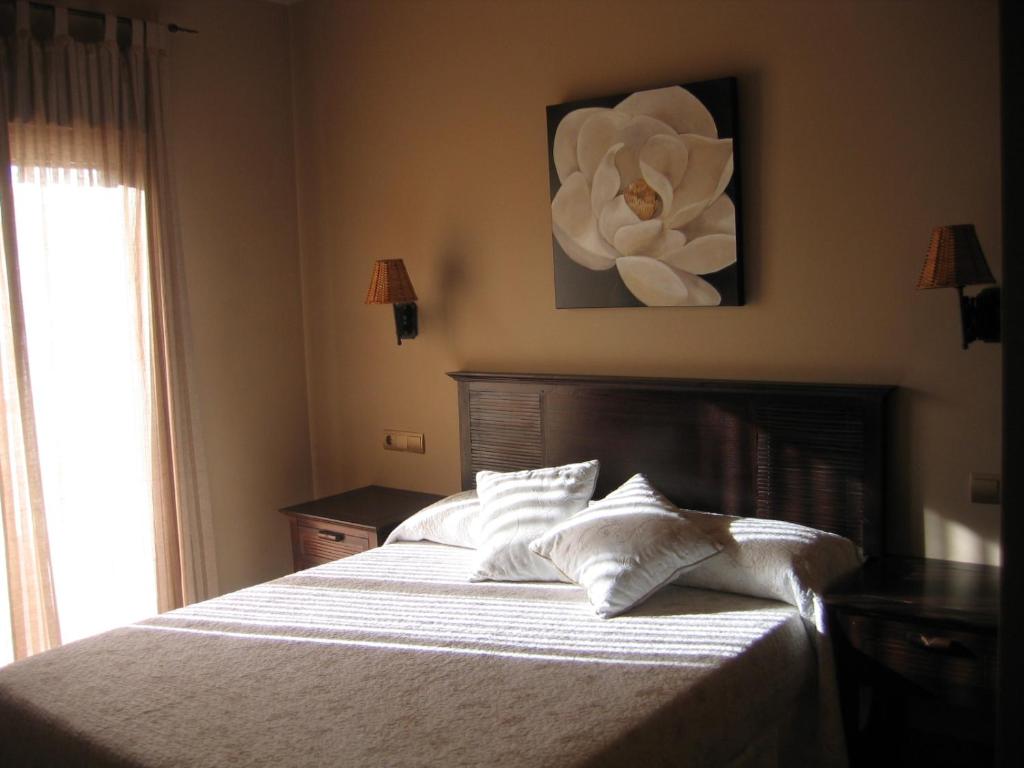 A bed or beds in a room at Hotel Rural Robles