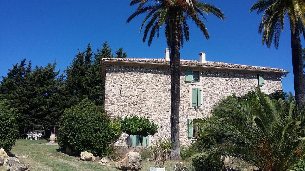 a stone building with a palm tree in front of it at Bastide les Buis in Roquebrune-sur-Argens