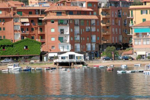 um grupo de barcos em uma massa de água com edifícios em Bi Hotel em Porto Ercole