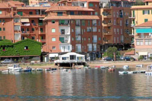 a group of boats in a body of water with buildings at Bi Hotel in Porto Ercole